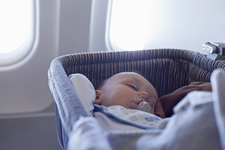 Baby schläft im Flugzeug in Bassinet