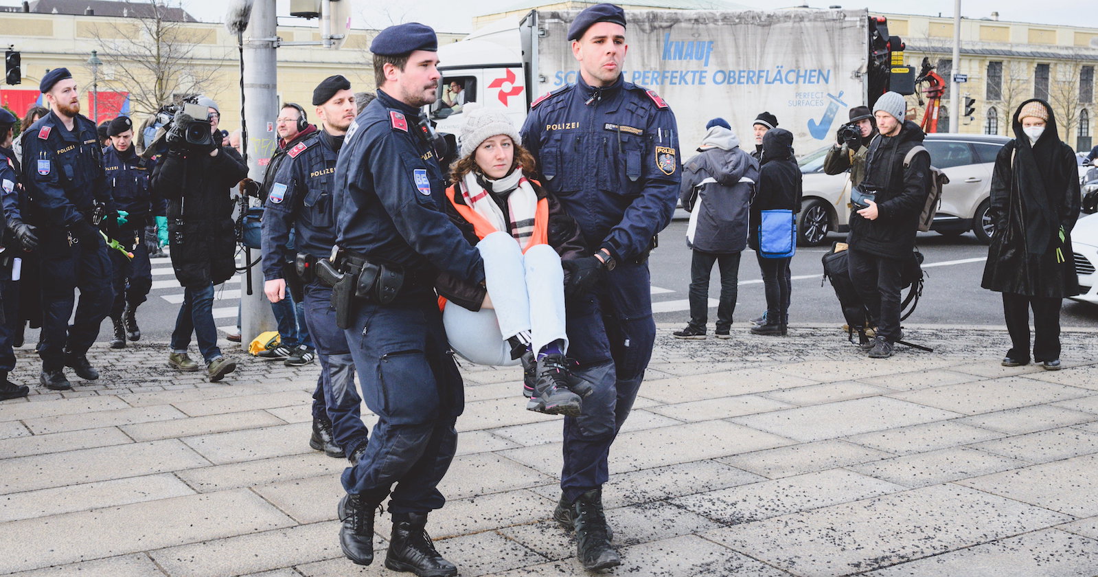 Ein Einsatz der Polizei. Zwei Beamte tragen ein junges Mädchen weg.