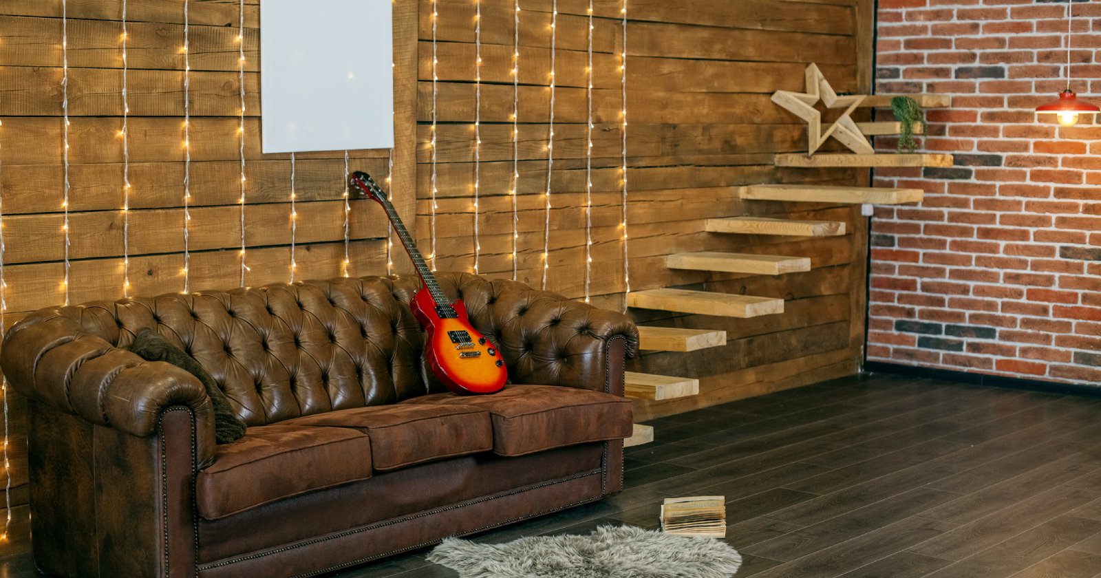 Eine Gitarre liegt auf einem Kunstledersofa | Credit: iStock.com/Olha Romaniuk