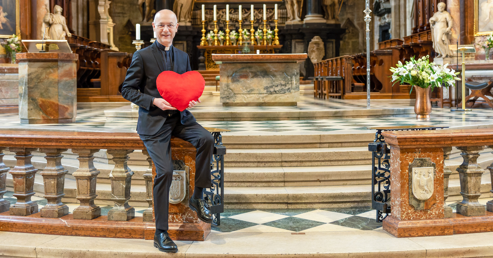 Dompfarrer Toni Faber hält am Altar ein Valentins-Herz| Credit: Stephan Schönlaub