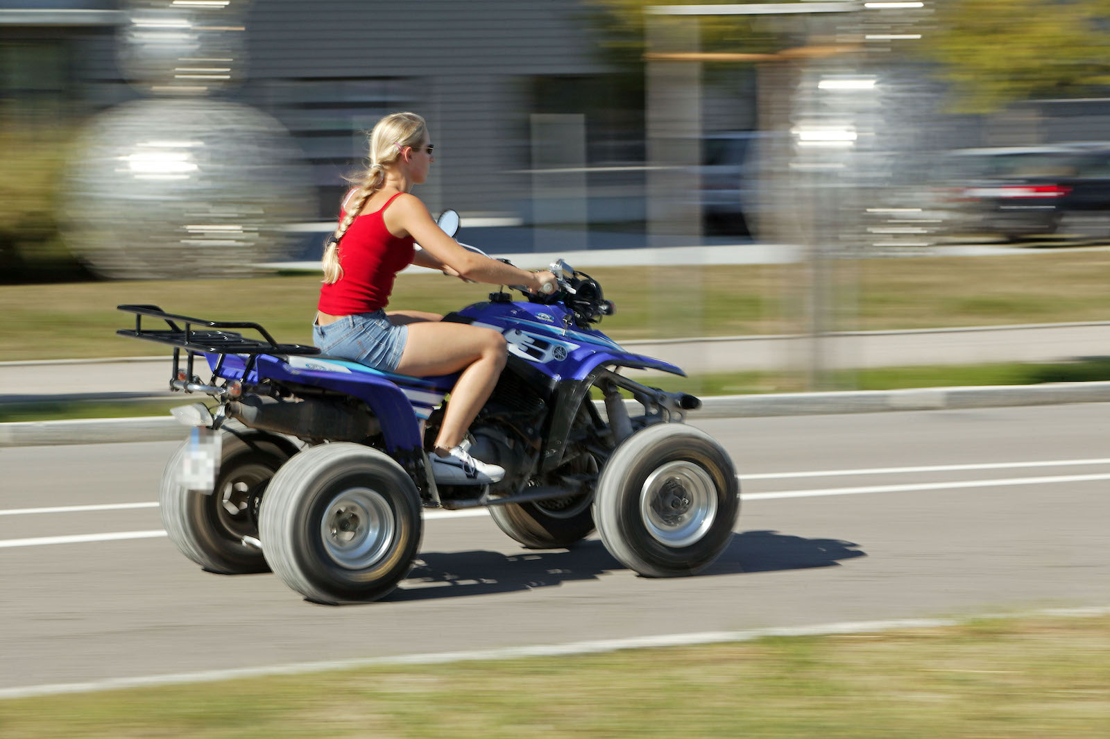 Frau fährt im Sommer ohne Helm ein Quad.