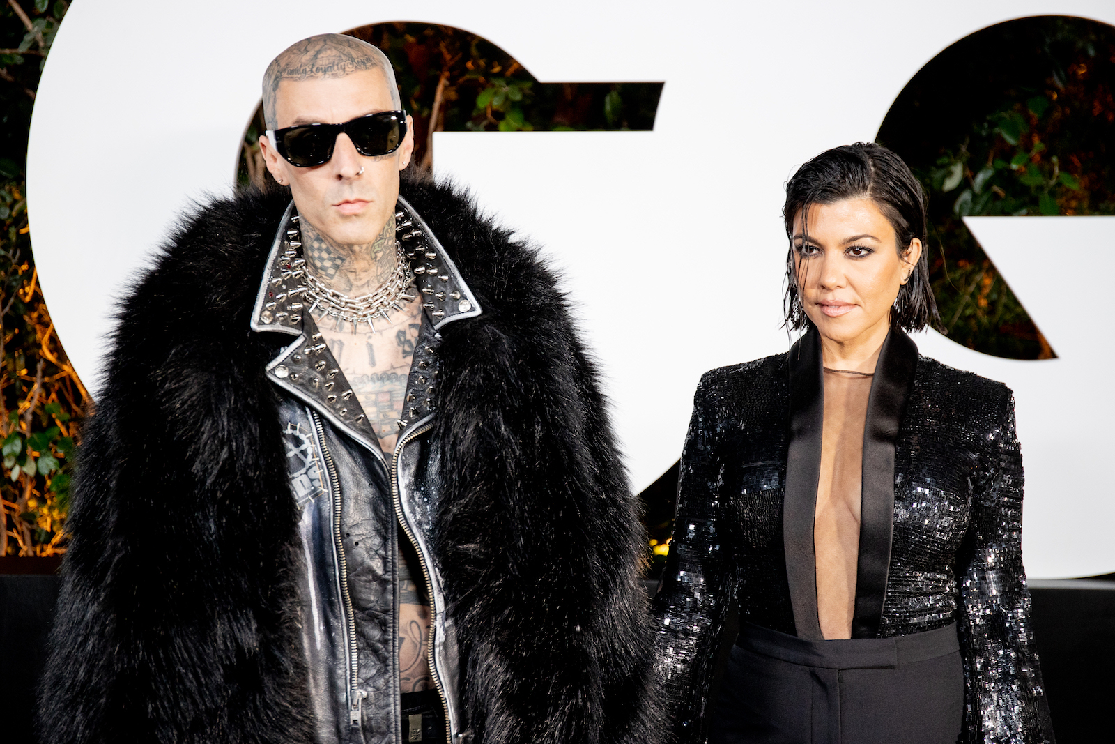 Kourtney Kardashian und Travis Barker schwarz gekleidet bei einem Event.