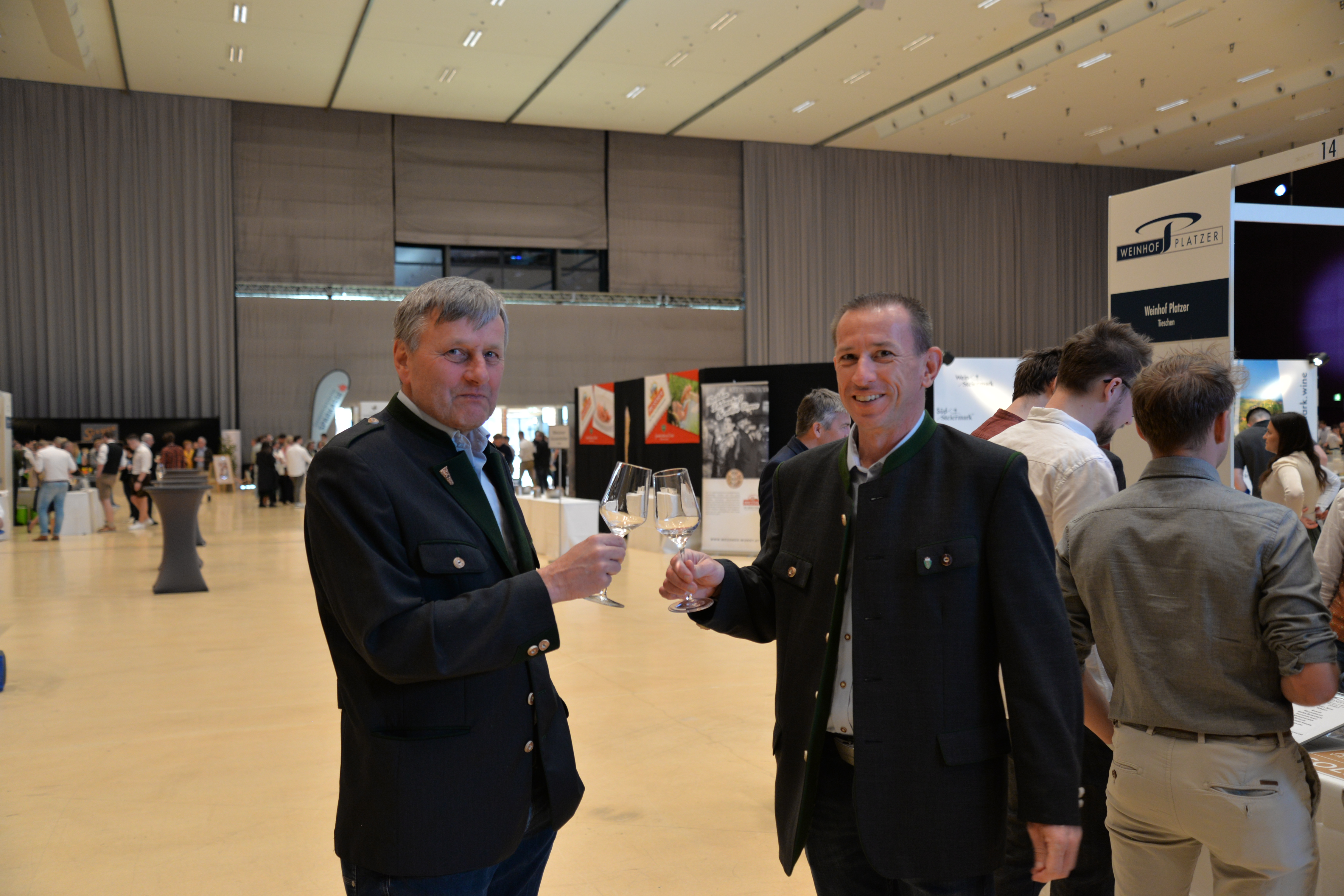 Zwei Gäste stoßen mit Wein an.