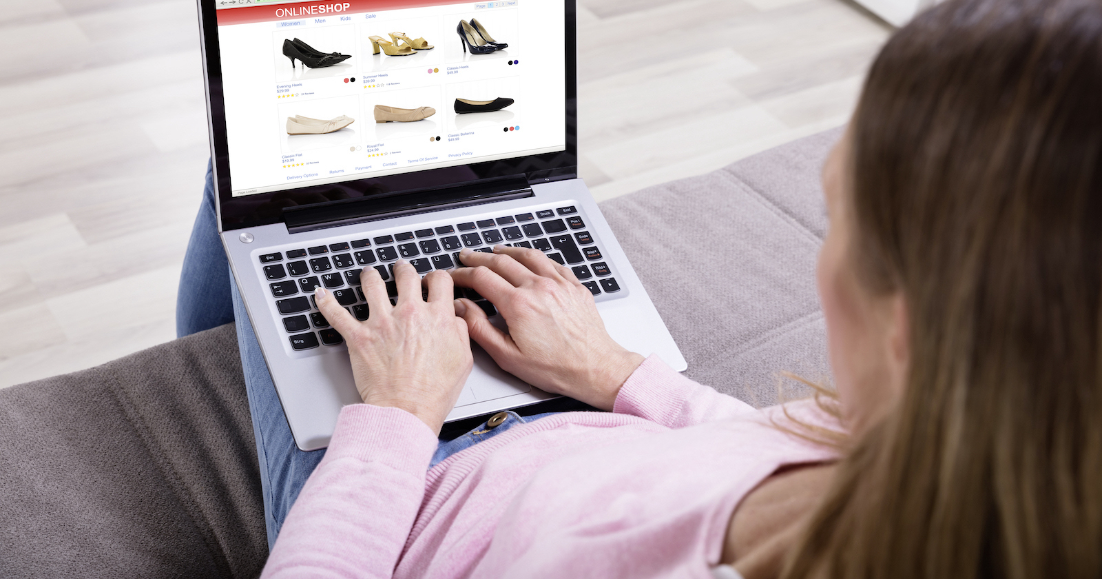 Frau tippt in Laptop mit Onlineshop am Display