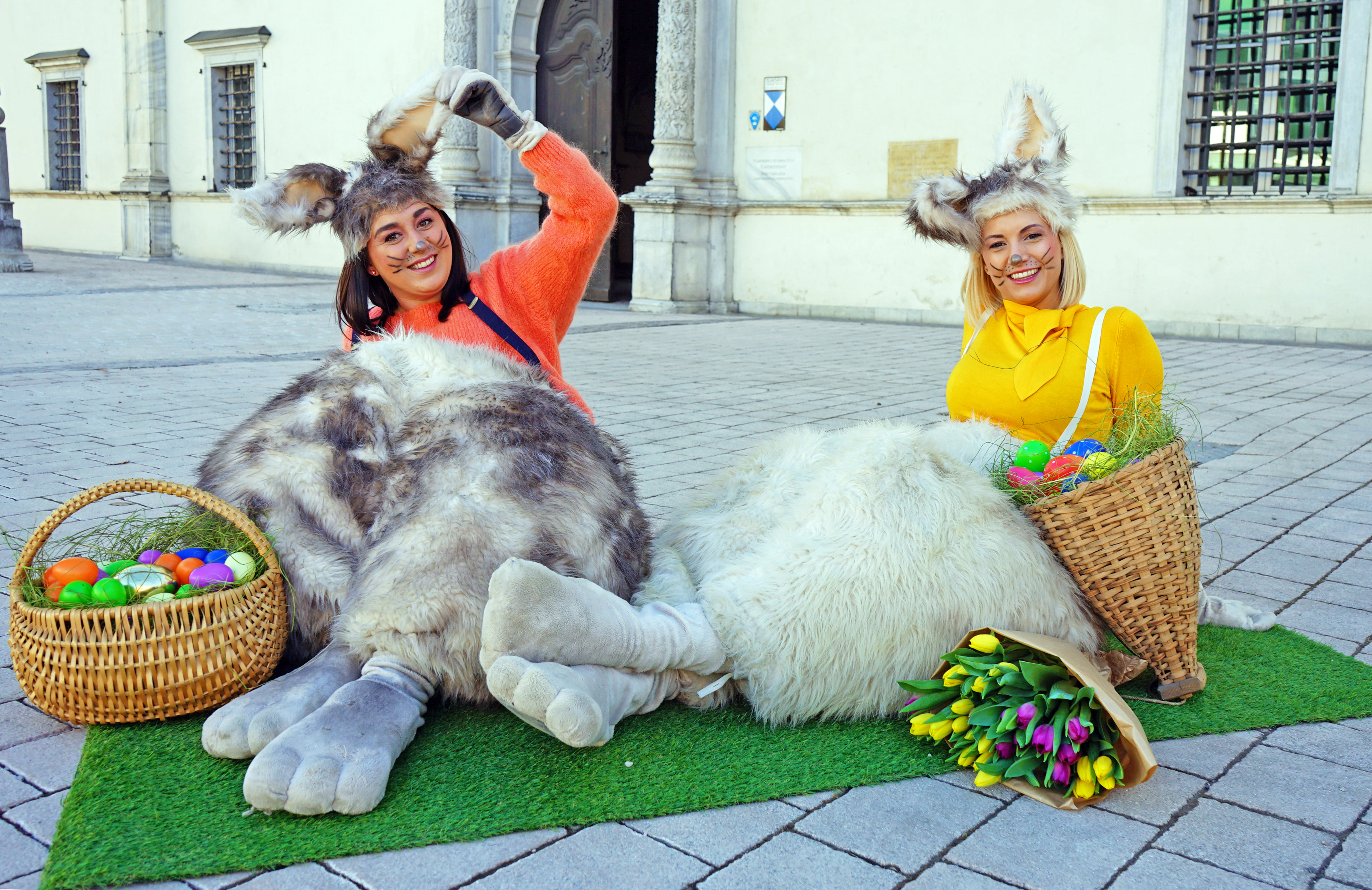 Zwei Frauen als Osterhasen verkleidet am Boden sitzend
