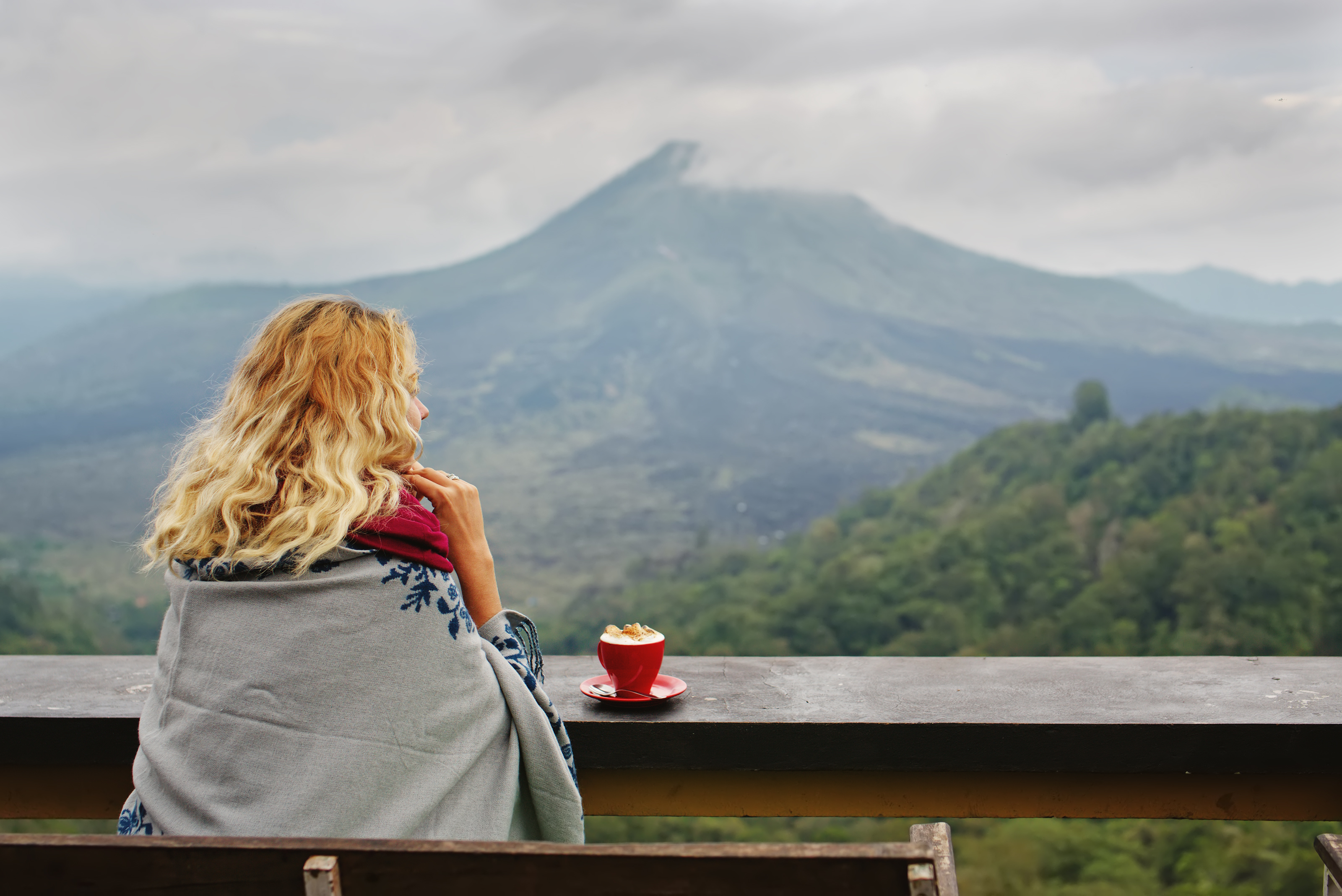 Frau von hinten im Grünen mit Tasse