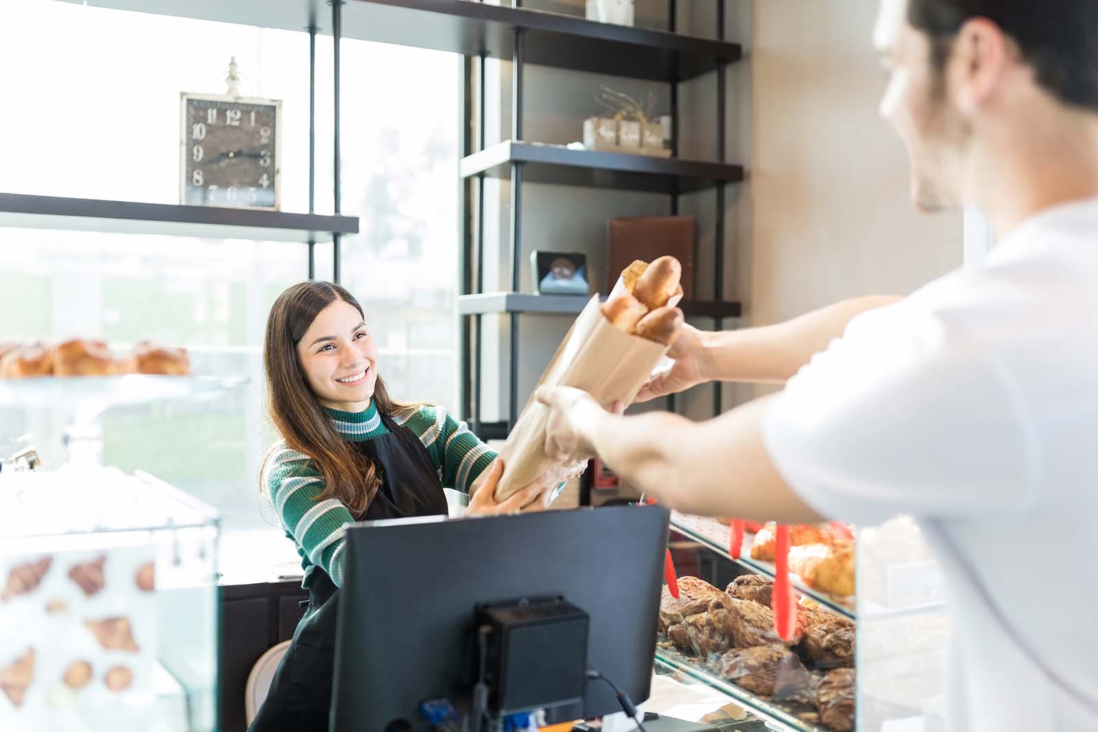 Bäckerin lächelt Kunden an | Credit: iStock.com/Antonio_Diaz