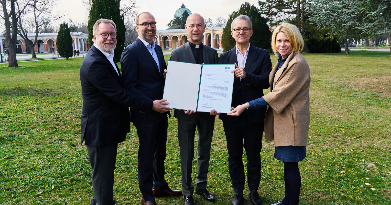 Bestatter und Toni Faber mit der Urkunde am Wiener Zentralfriedhof | Credit: Bundesverband der Bestatter:innen/Harald Artner