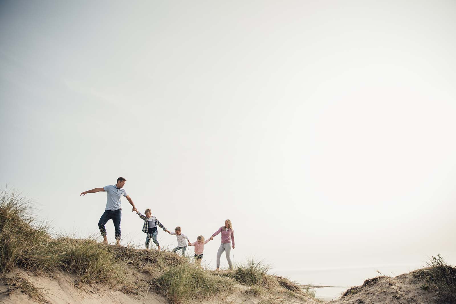 Familie wandert gemeinsam am Meer entlang | Credit: iStock.com/DGLimages