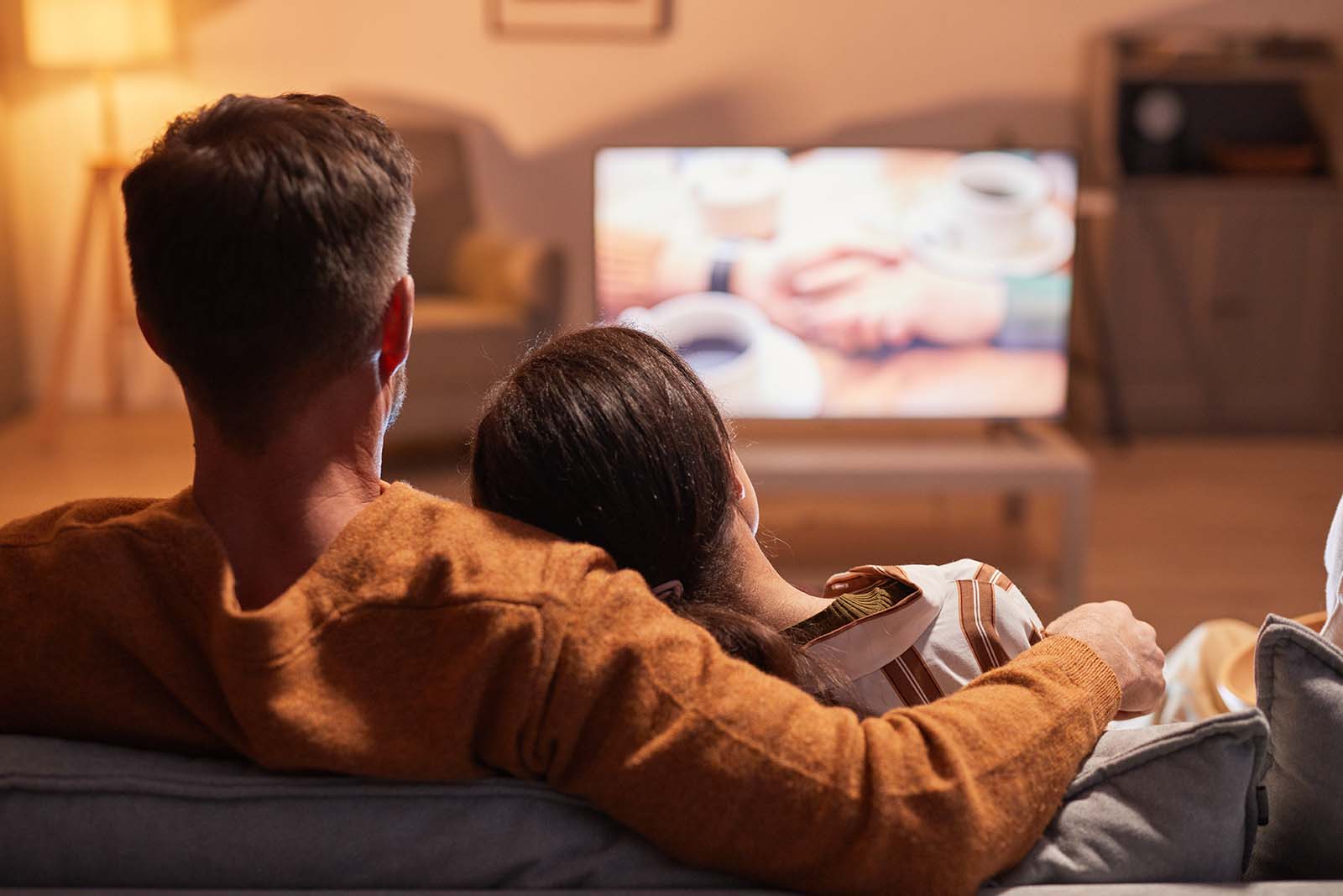 Paar sitzt gemeinsam vor dem Fernseher | Credit: iStock.com/SeventyFour