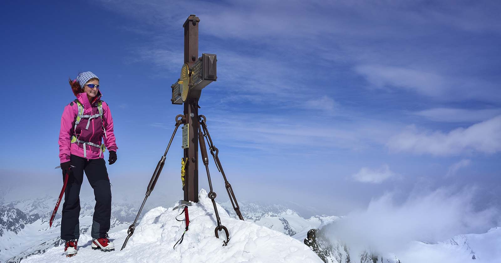 Frau steht am Gipfelkreuz vom Großglockner | Credit: Andreas Strauß / Lookphotos / picturedesk.com