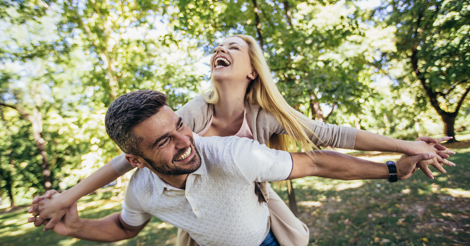 Pärchen läuft glücklich durch den Wald | Credit: iStock.com/Jovanmandic