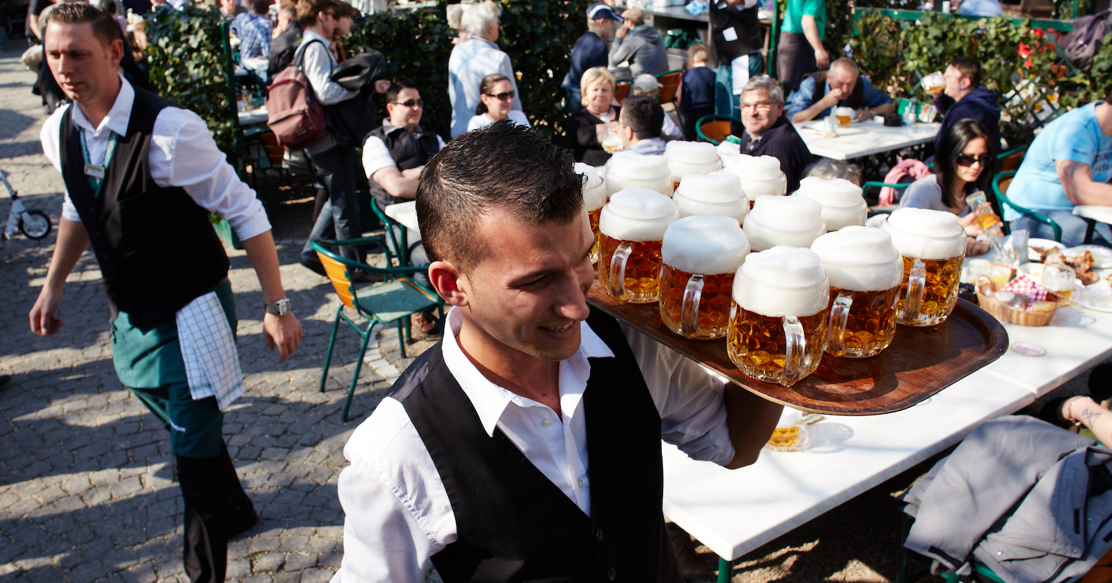 Ein Kellner trägt ein Tablett mit Biergläsern durch den Schweizerhaus-Gastgarten | Credit: Tesarek