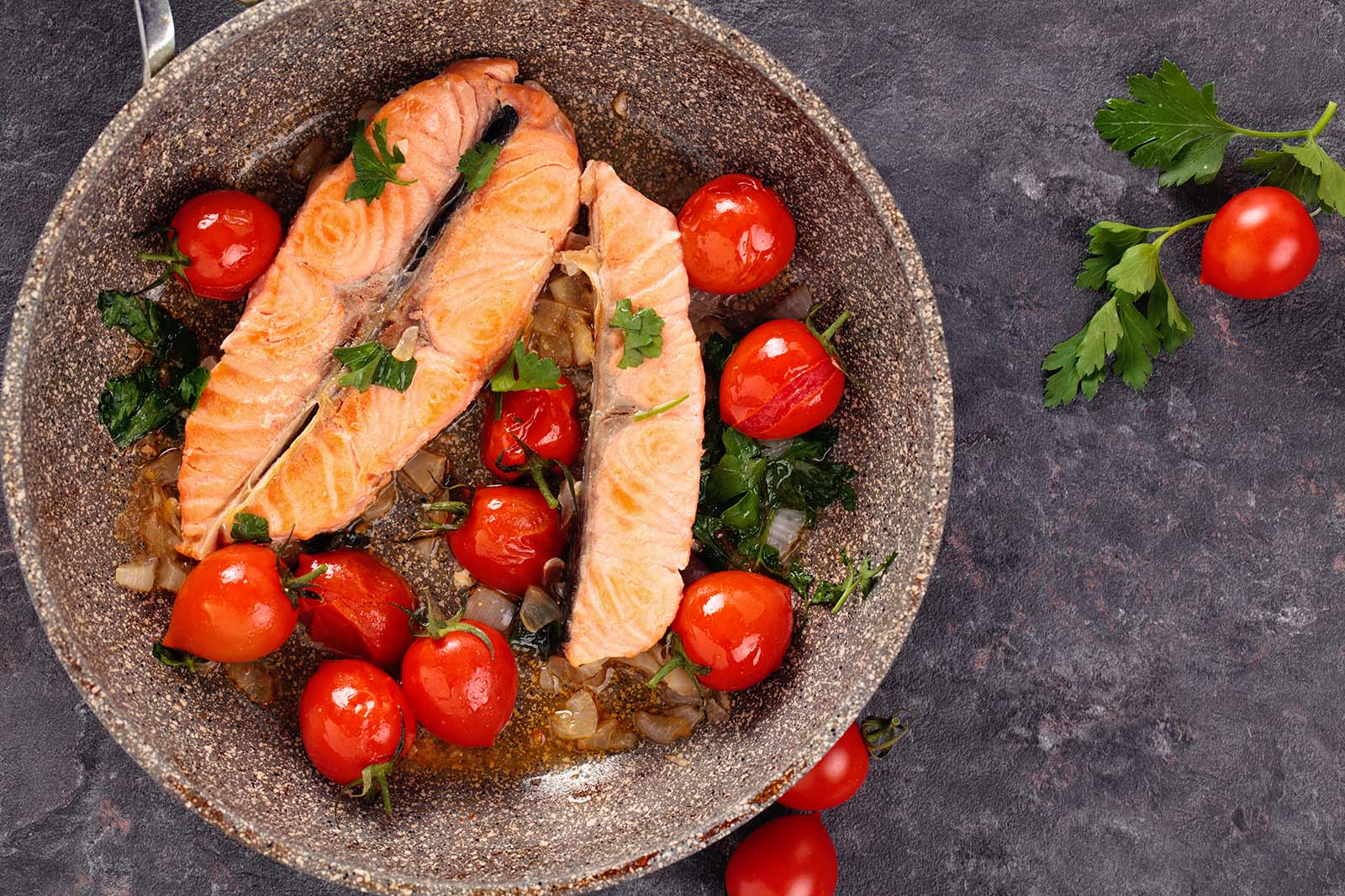 Gebratener Lachs mit Tomatensalat in einer Schale | Credit: iStock.com/Vitalina