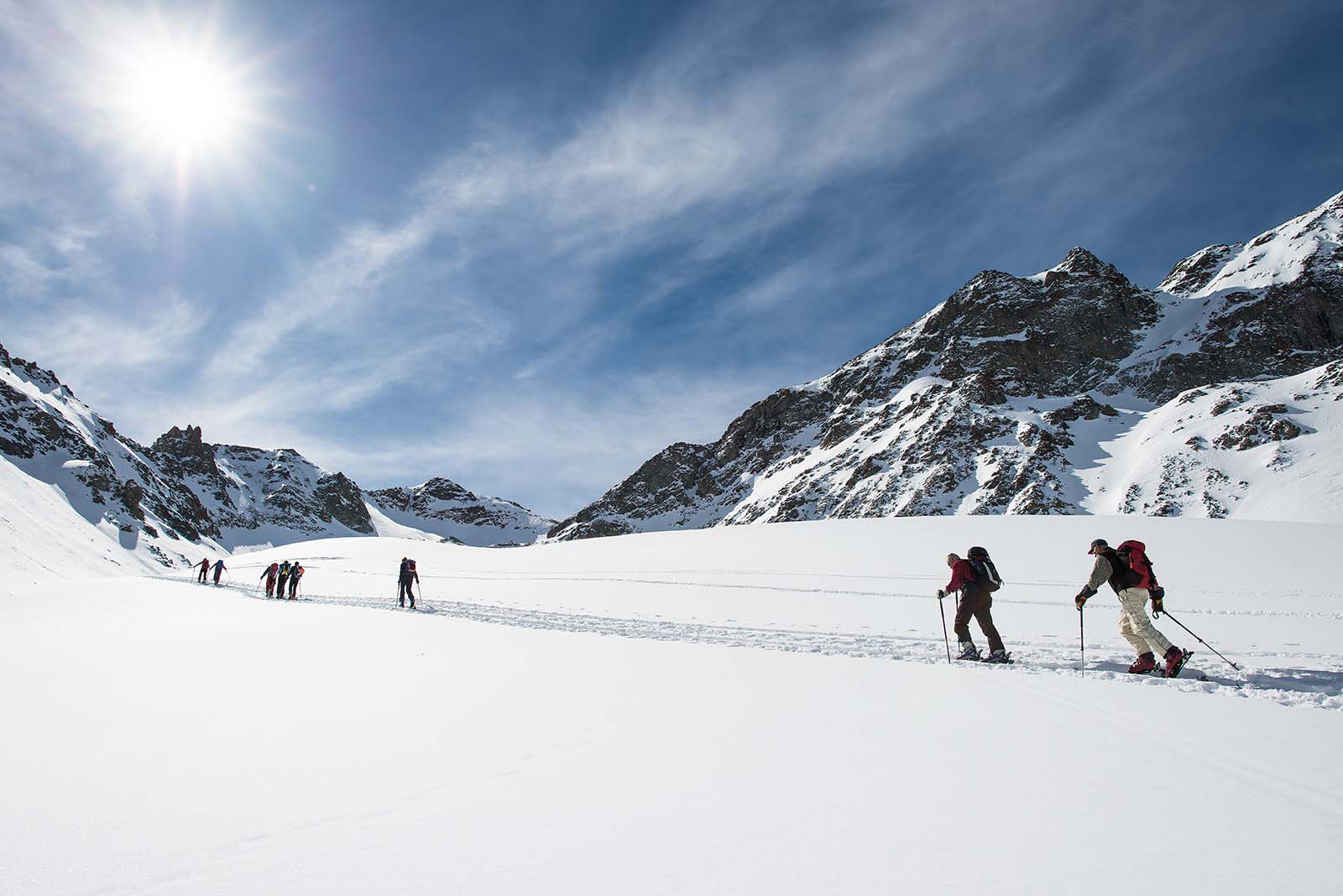 Eine Gruppe wandert im Schnee einen Berg hinauf | Credit: iStock.com/michelangeloop