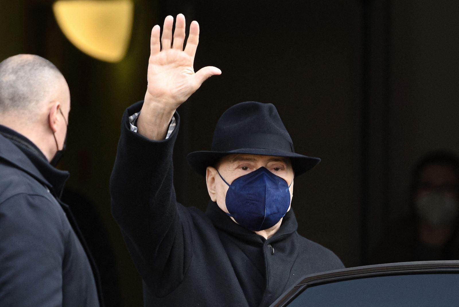 Silvio Berlusconi mit FFP2-Maske winkt den Journalisten zu.