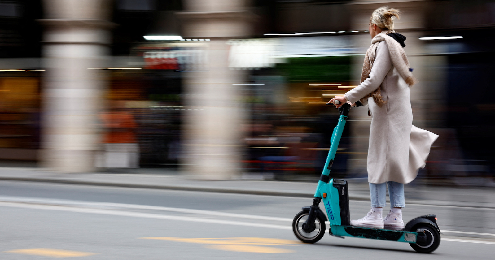 Frau fährt auf einem E-Scooter in Paris