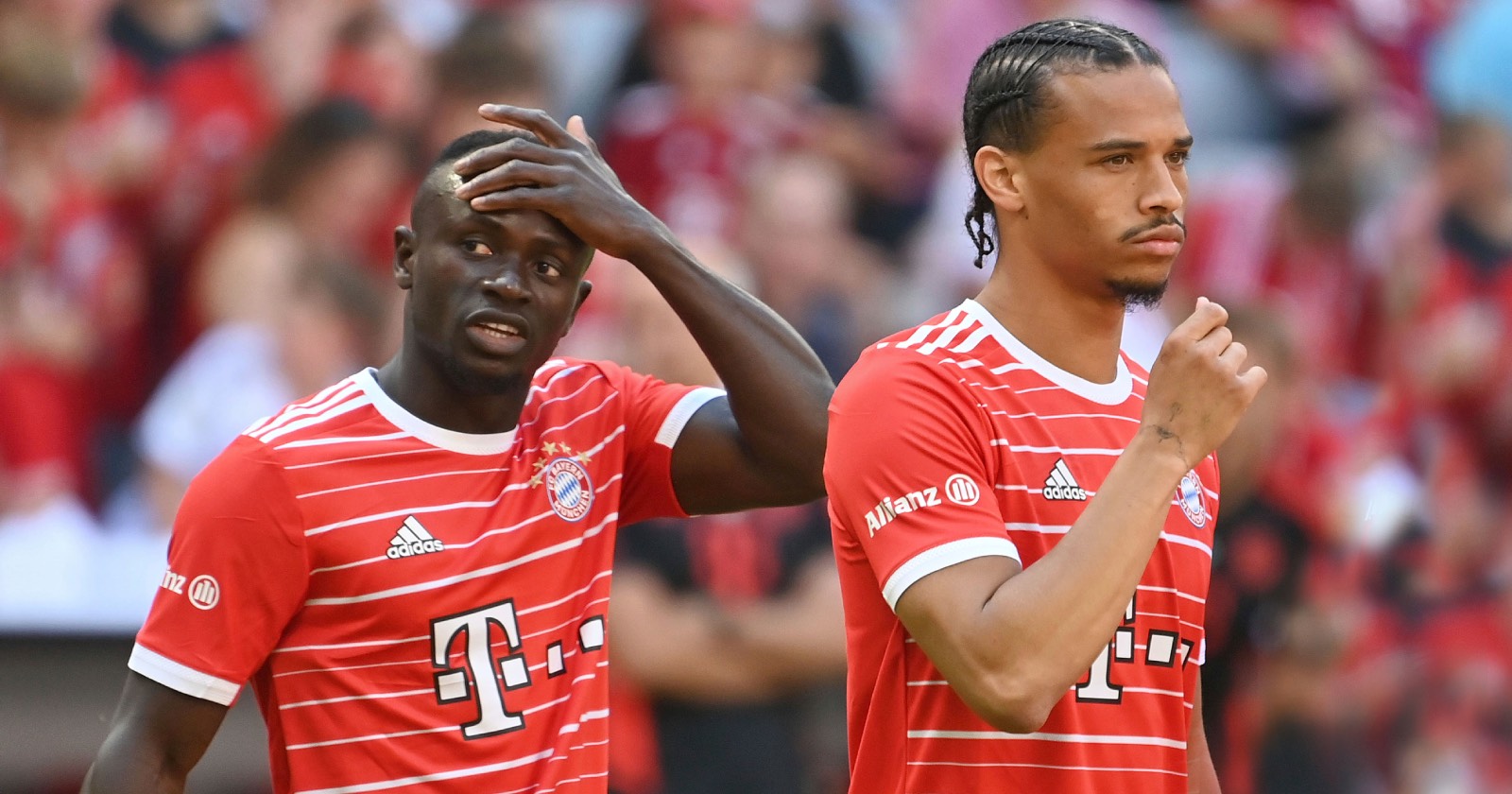 Sadio Mané und Leroy Sané, die mit ratlosem Gesichtsausdruck im Bayern-Dress über den Platz marschieren