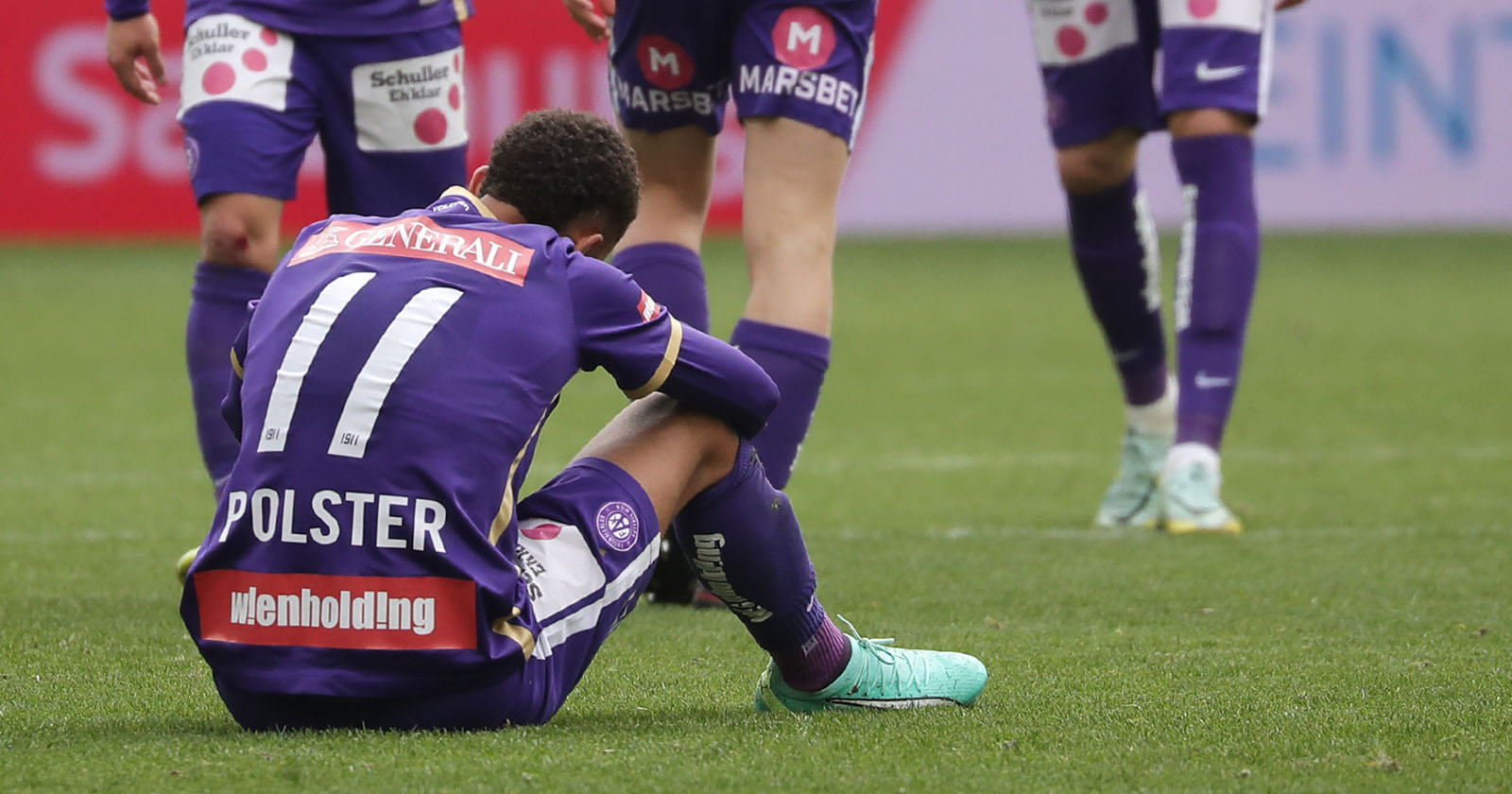 Enttäuschter Austria Wien Spieler sitzt auf dem Spielfeld