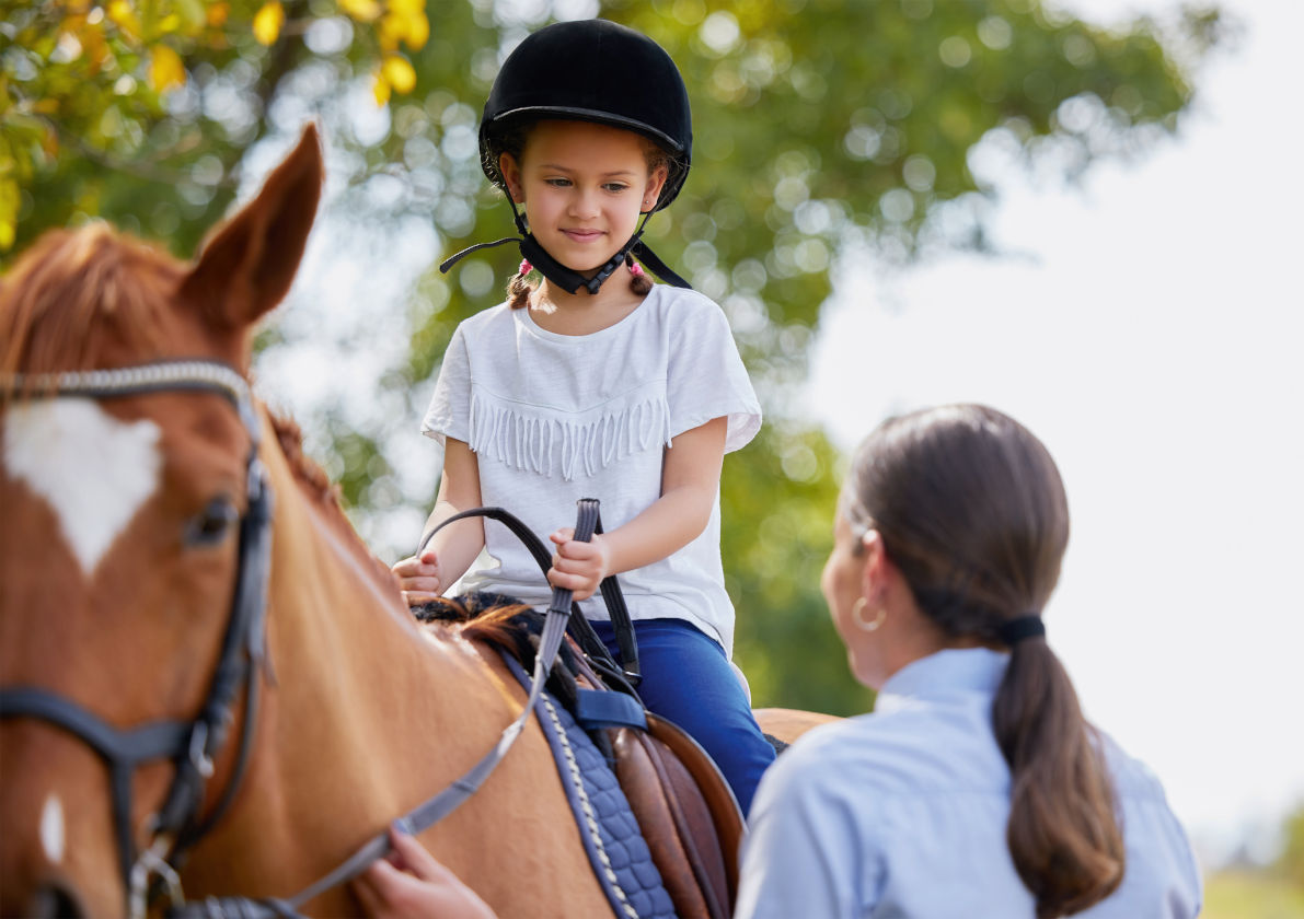 Mädchen auf Pferd beim Reiten