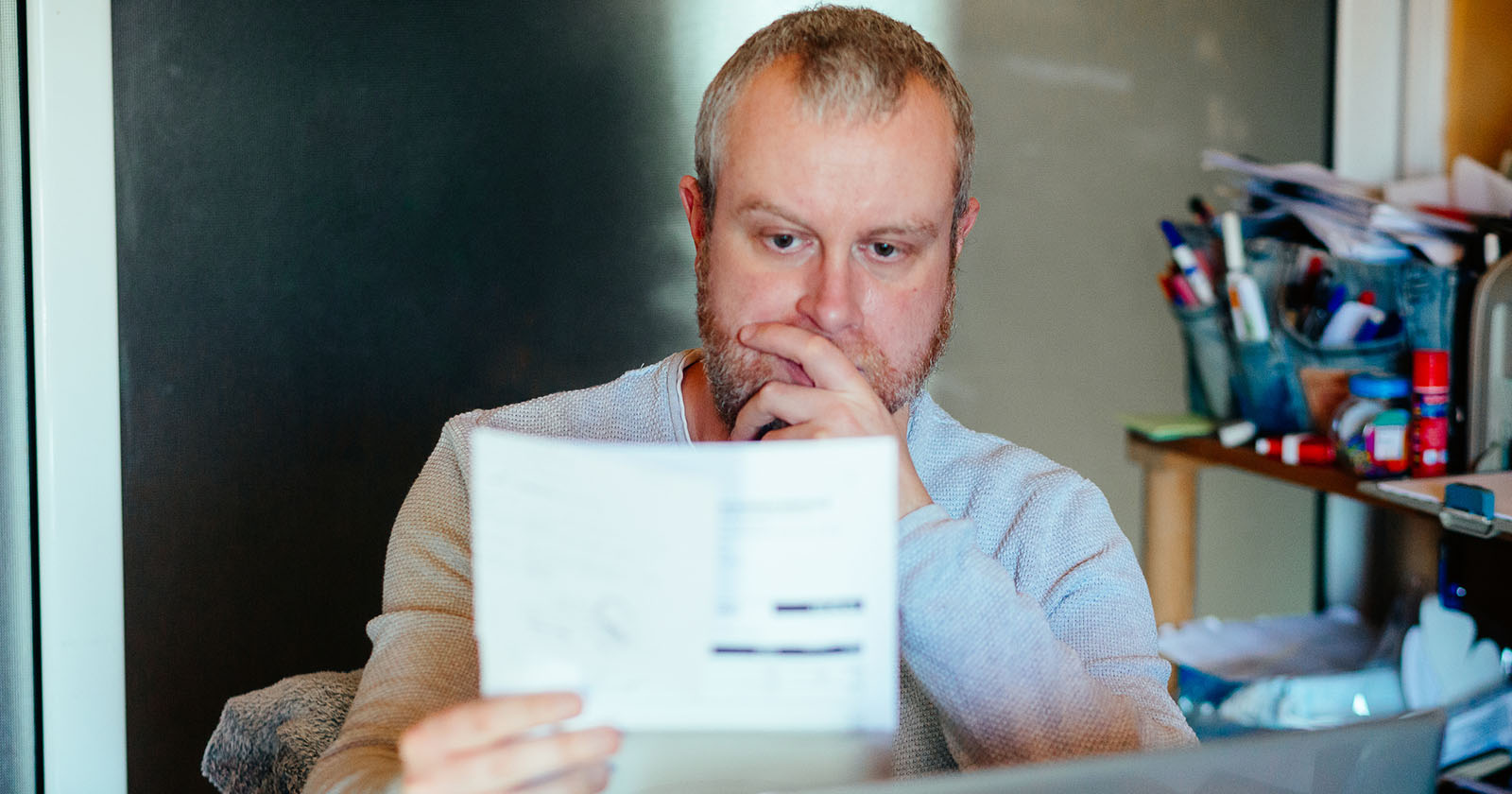 Mann schaut mit Besorgnis auf eine Rechnung