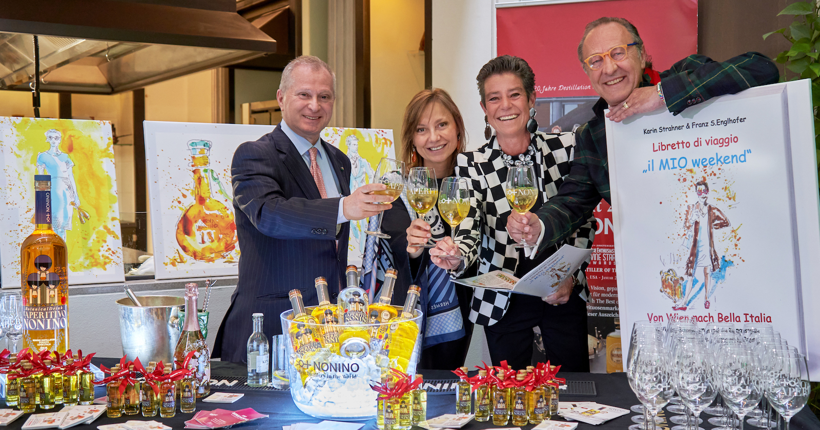 4 Personen stoßen vor Buchplakat an