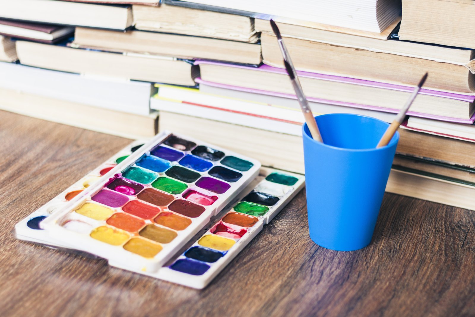 Bücher mit Malfarben und einem Pinselset | Credit: iStock.com/Inna Luzan