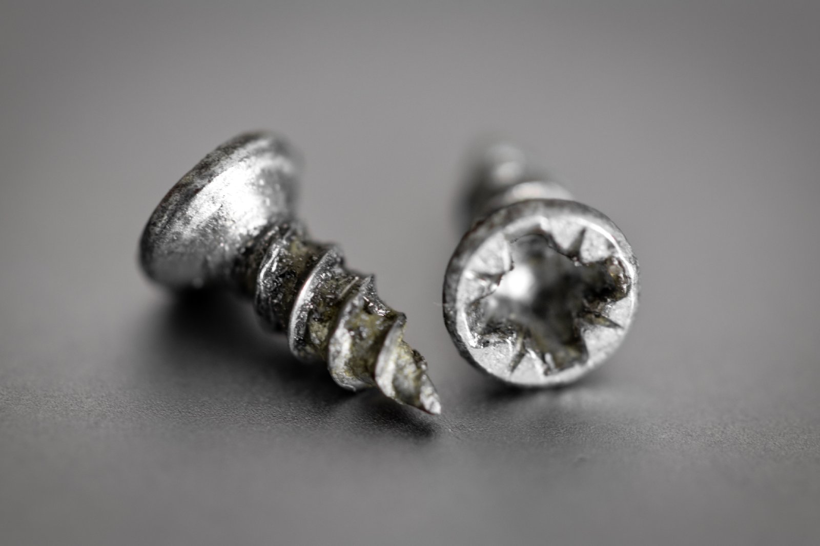 Kaputte Schrauben liegen auf einem Tisch | Credit: iStock.com/Lenti Hill