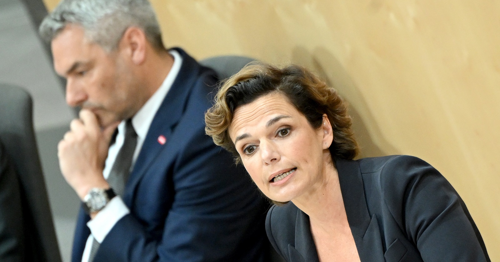 Rendi-Wagner am Redner-Pult im Parlament. Im Hintergrund Nehammer auf der Regierungsbank.