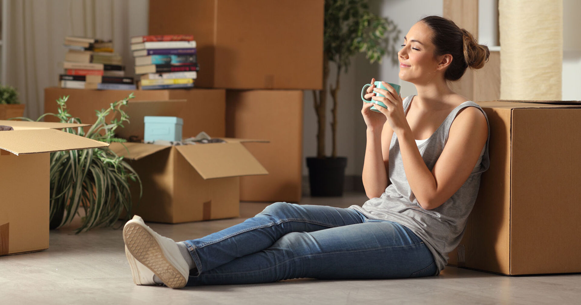 Junge Frau beim Entrümpeln ihrer Wohnung | Credit: iStock.com/AntonioGuillem