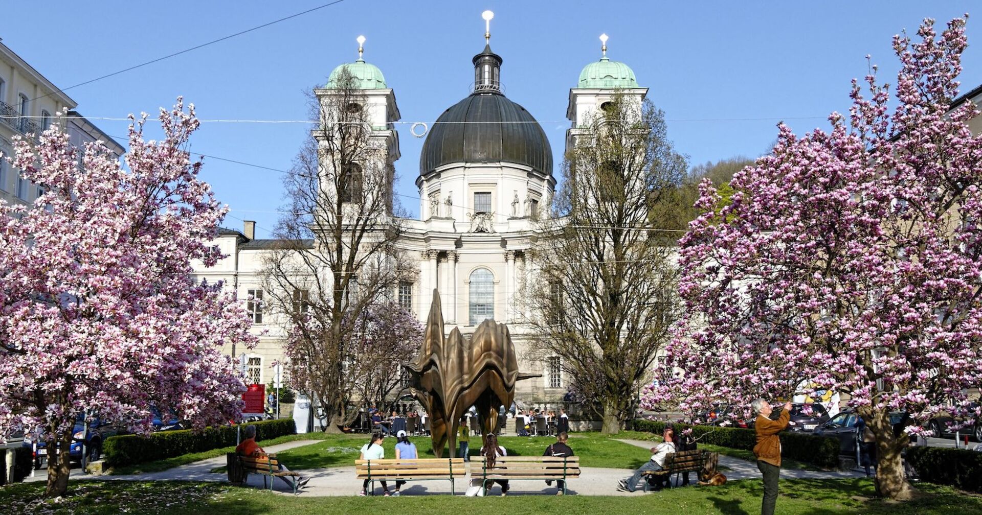 Der Makartplatz in Salzburg mit der Dreifaltigkeitskirche und blühenden Magnolien.