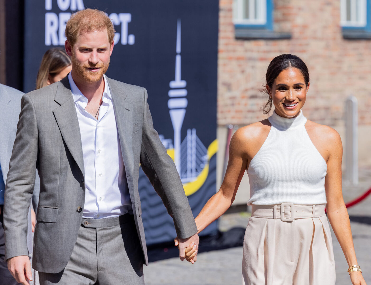 Harry und Meghan halten in der Öffentlichkeit Händchen.