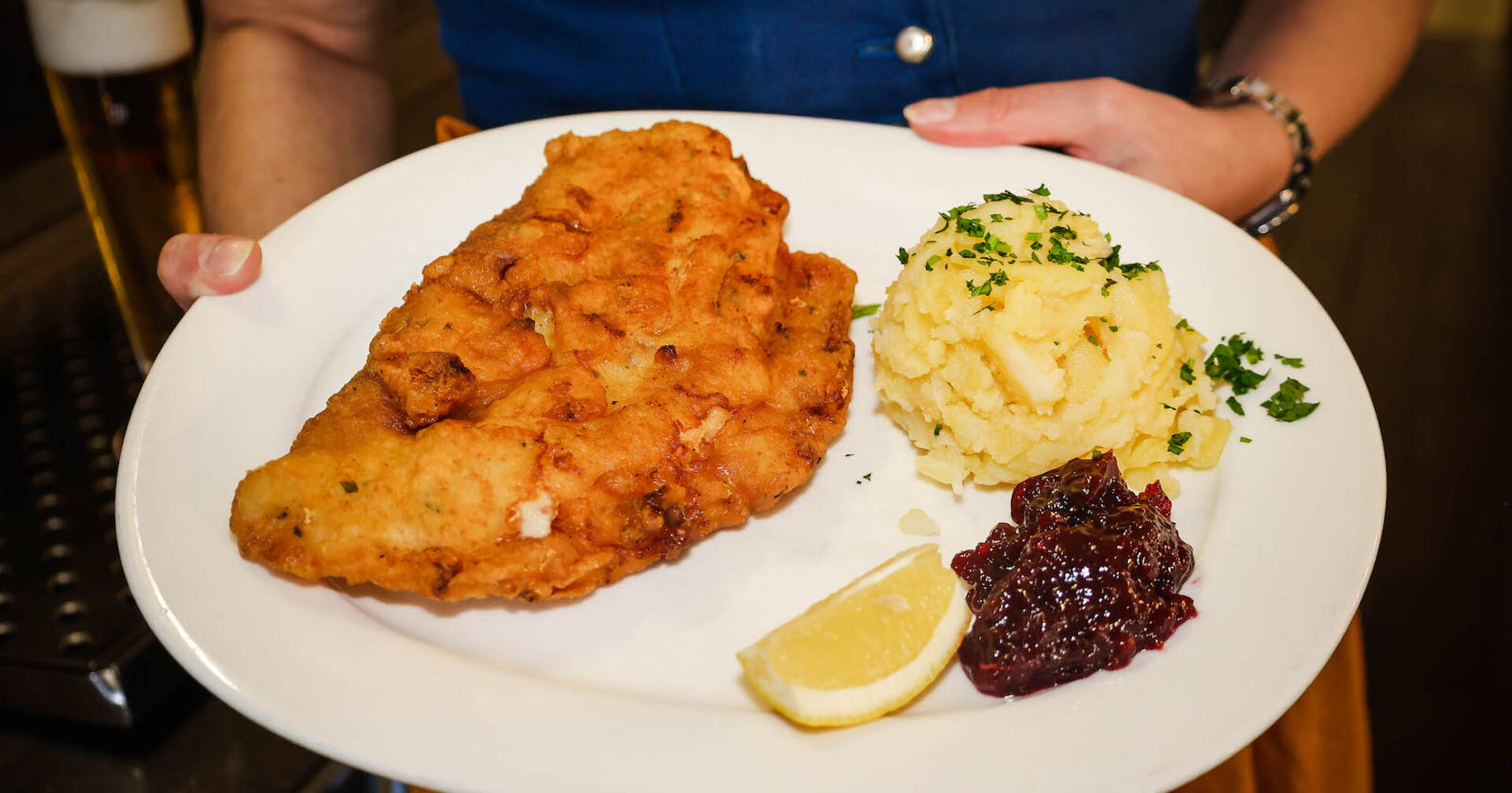 Ein Schnitzel mit Preisselbeermarmelade und Kartoffelsalat.