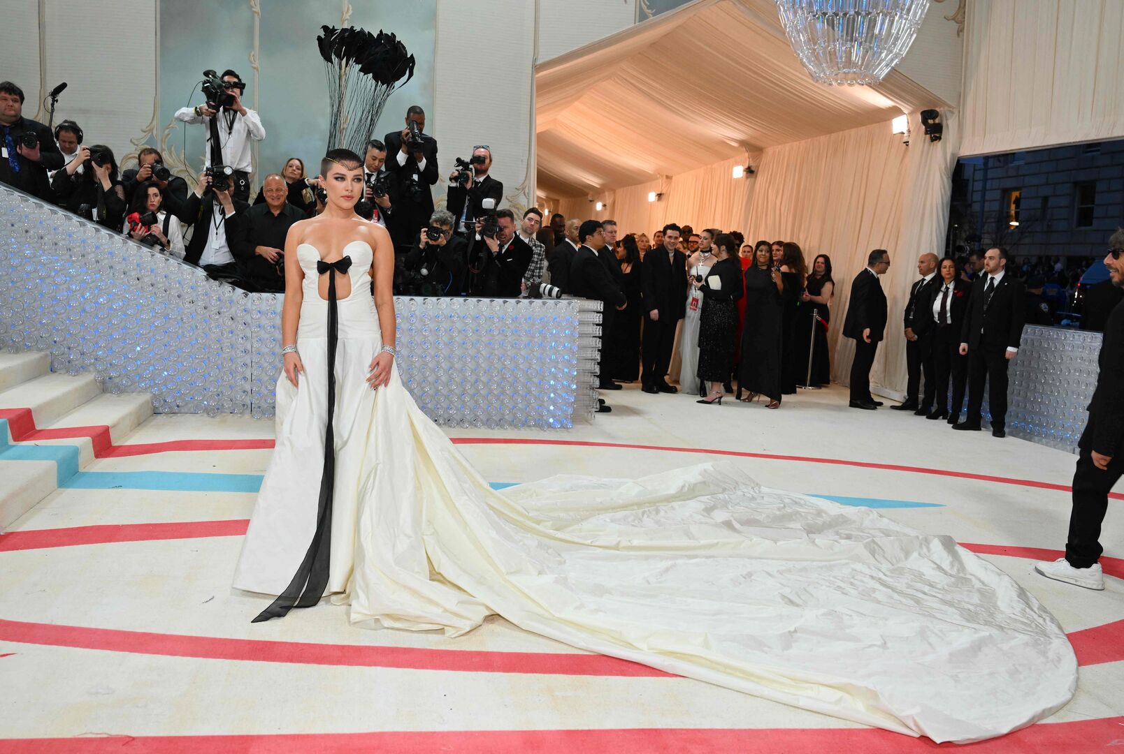 Florence Pugh in einer weißen Robe mit schwarzer Schleife