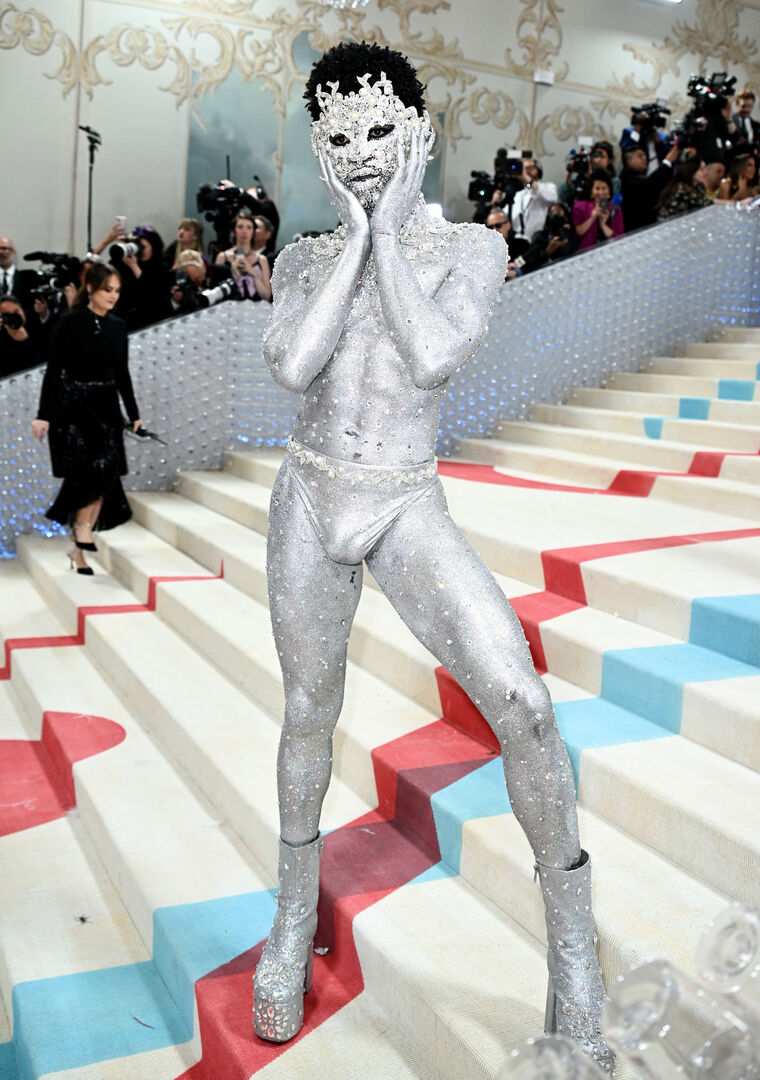 Lil Nas X mit silbernem Bodypainting und vielen Edelsteinen.