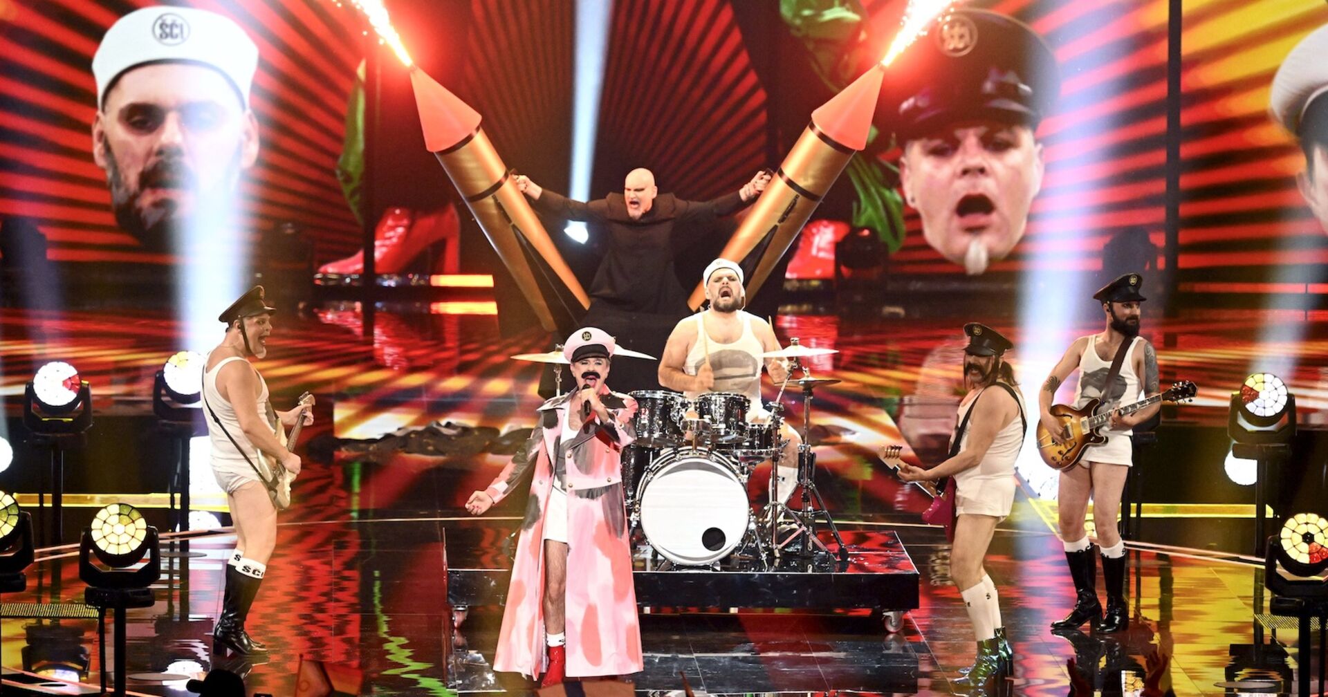 Männer singen in schrillen Militäruniformen auf einer bunten Bühne | Credit: Vesa Moilanen / Lehtikuva / picturedesk.com