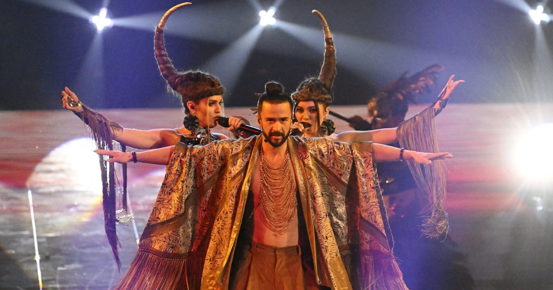 Mann im Umhang und Frauen mit Horn am Kopf stehen auf der Bühne  | Credit: Vesa Moilanen / Lehtikuva / picturedesk.com