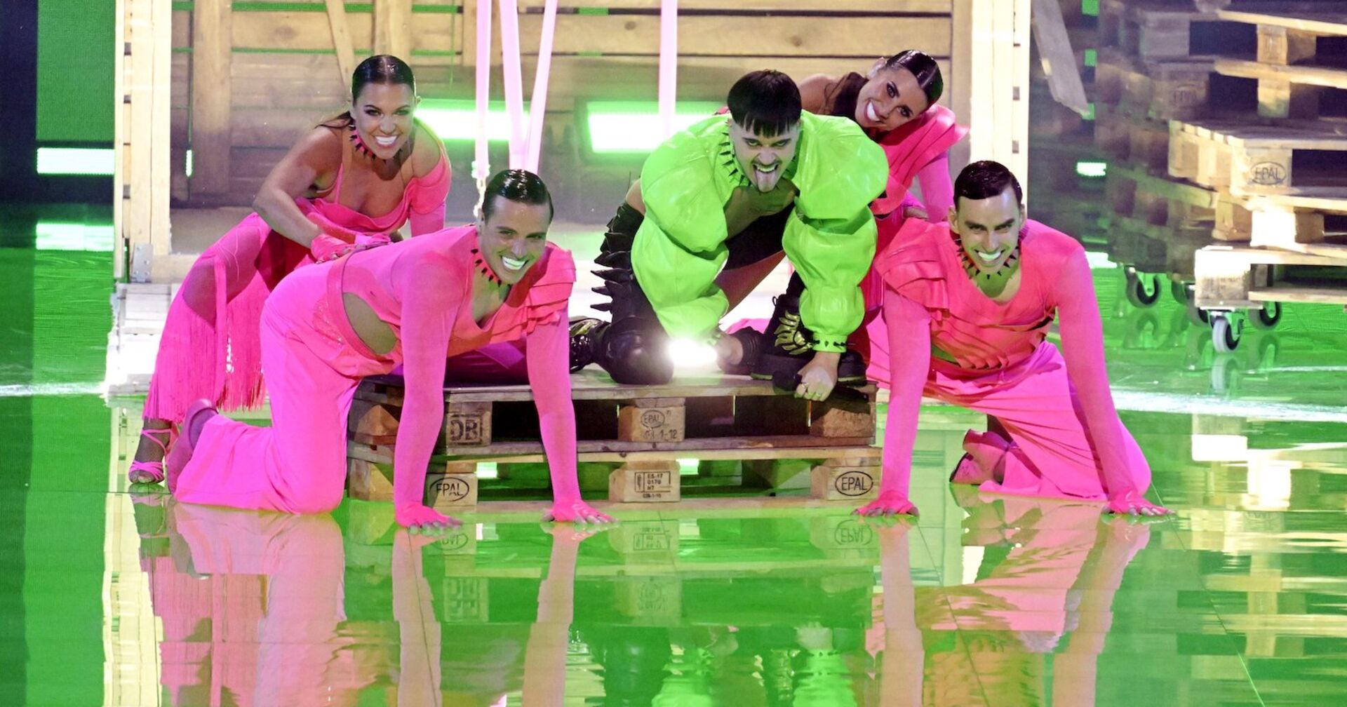 Sänger in grünem Bolero kriecht mit rosa gekleideten Tänzern auf der Bühne herum | Credit: Vesa Moilanen / Lehtikuva / picturedesk.com