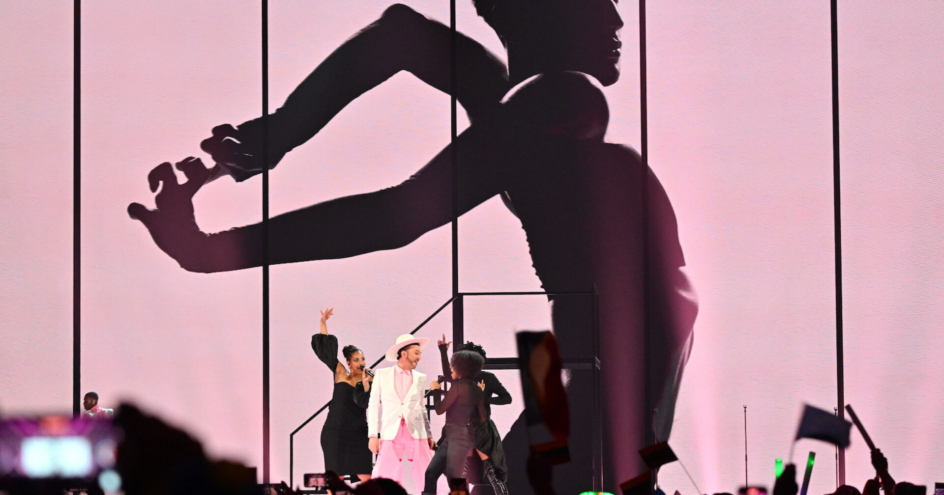 Sänger mit rosaa Anzug und weißem Hut mit drei Background-Sängerinnen | Credit:  Peter Kneffel / dpa / picturedesk.com