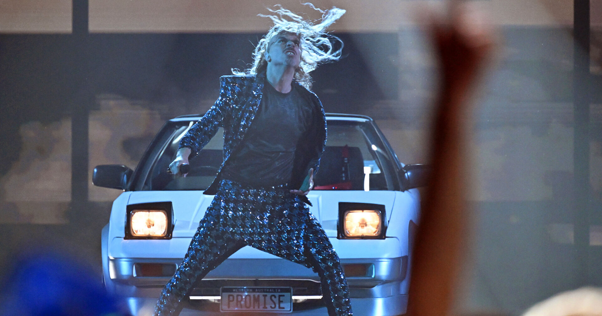 Rocksänger im Glitzeranzug vor einem Auto | Credit:  Peter Kneffel / dpa / picturedesk.com