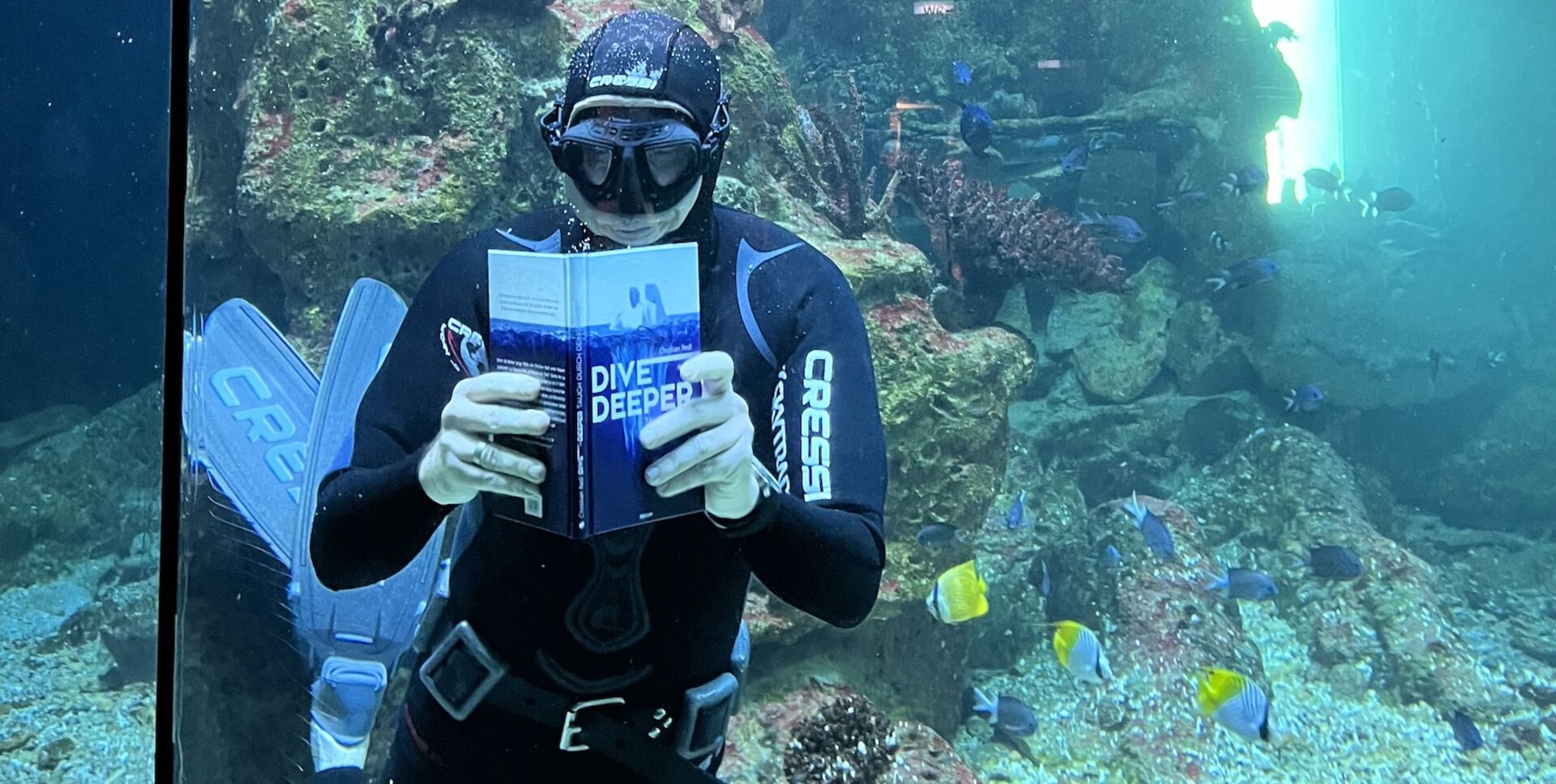 Christian Redl liest in seinem neuen Buch im Taucheranzug | Credit: novum Verlag