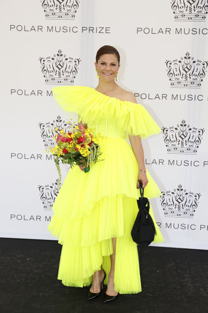 Kronzprinzessin Victoria in einem gelben Kleid mit Blumen und schwarzer Handtasche