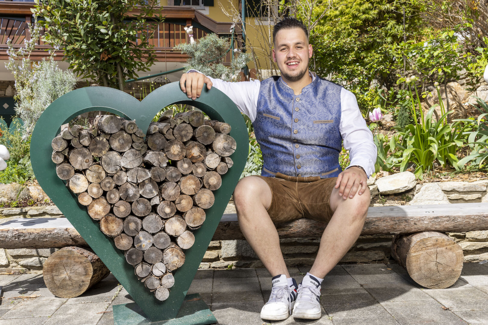 Lukas mit einem Herz aus Holz.