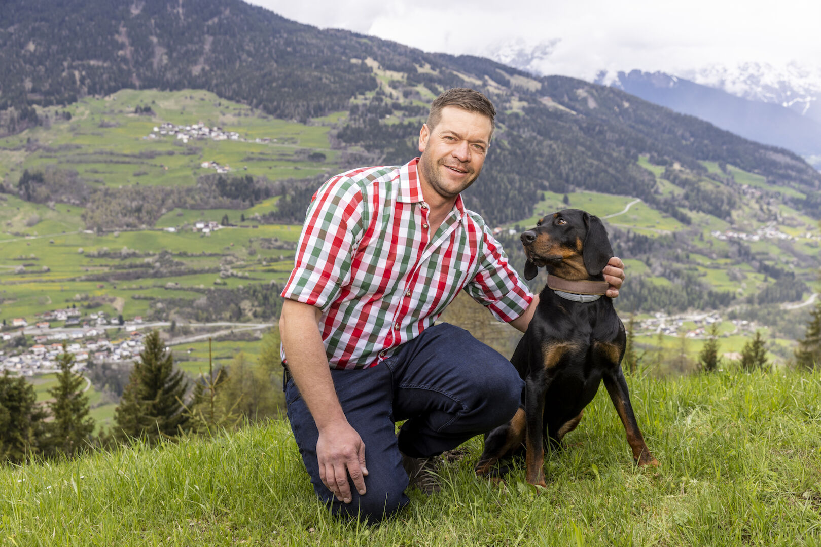 Mike mit seinem Hund auf einer Wiese.