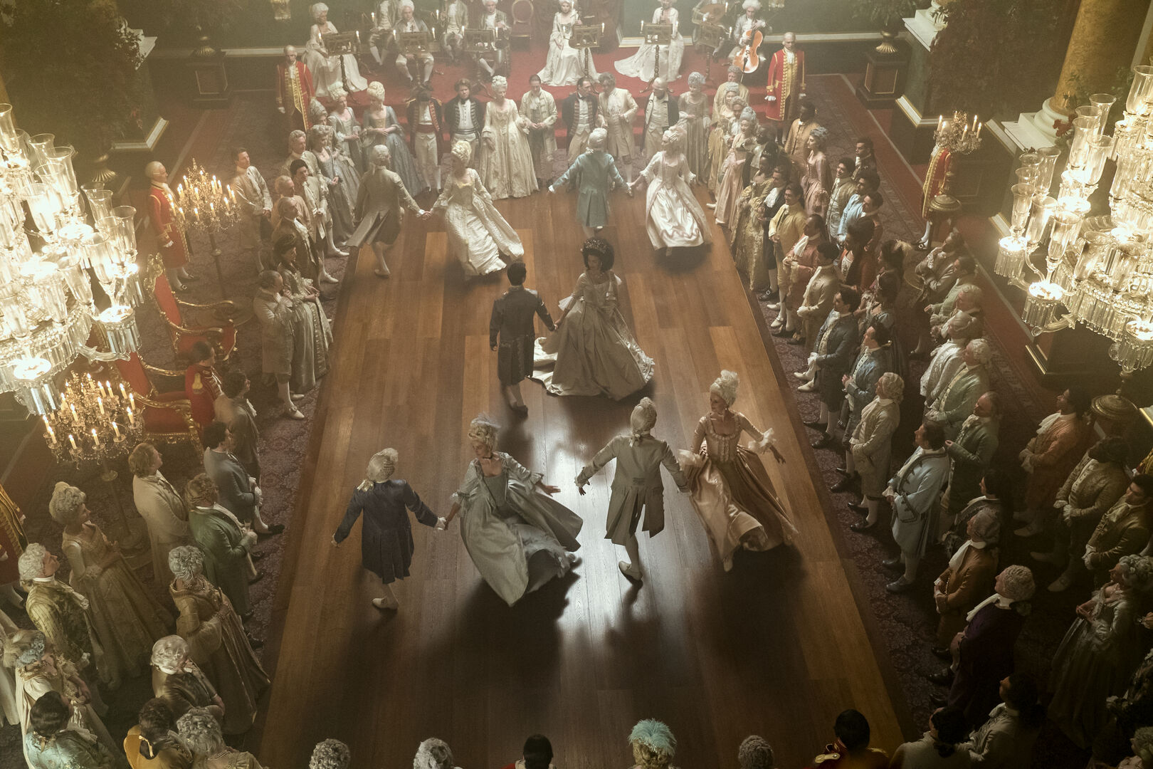 Höfisch gekleidete Menschen tanzen auf einem Ball