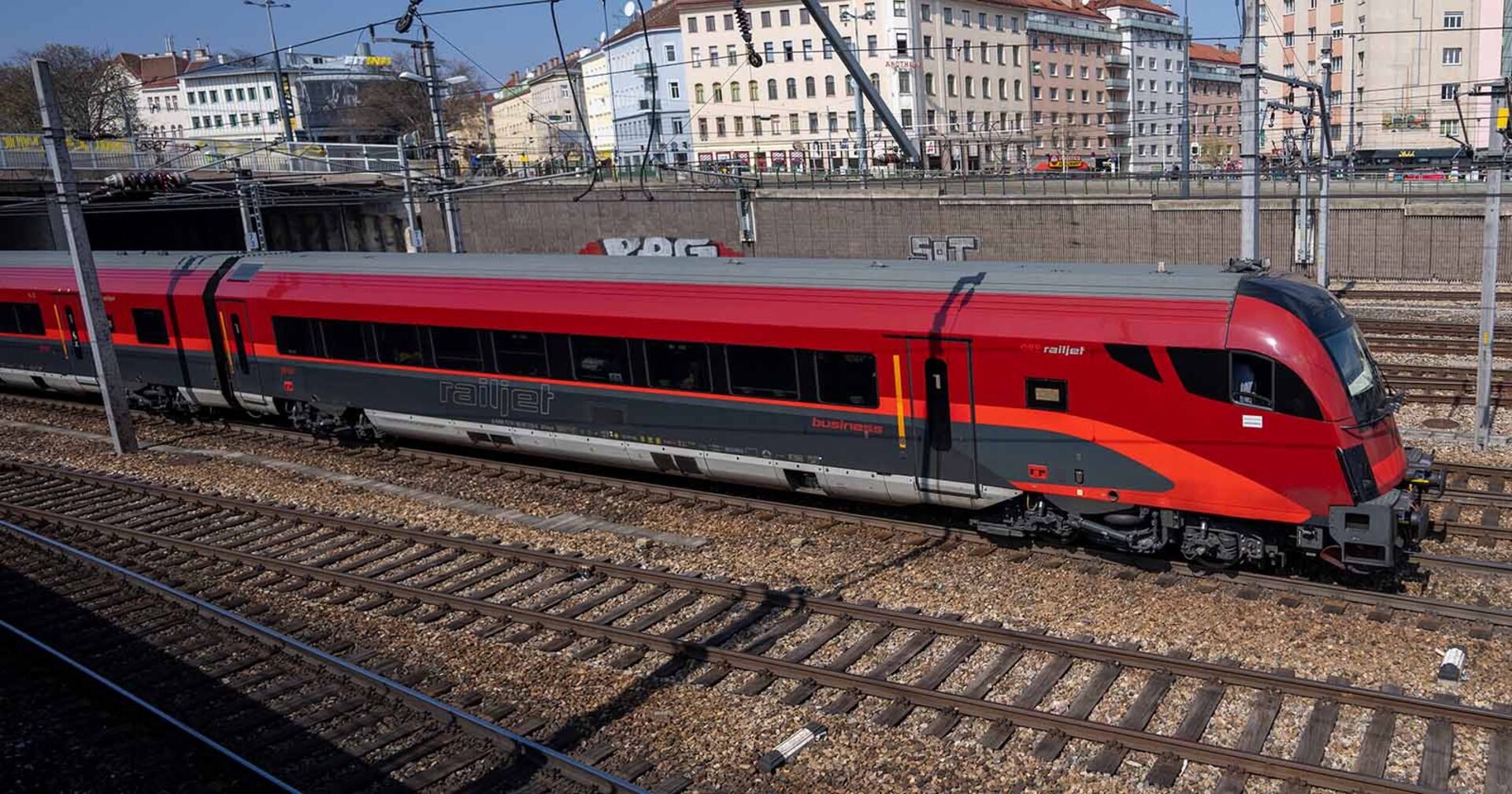 Railjet der ÖBB fährt aus einem Bahnhof