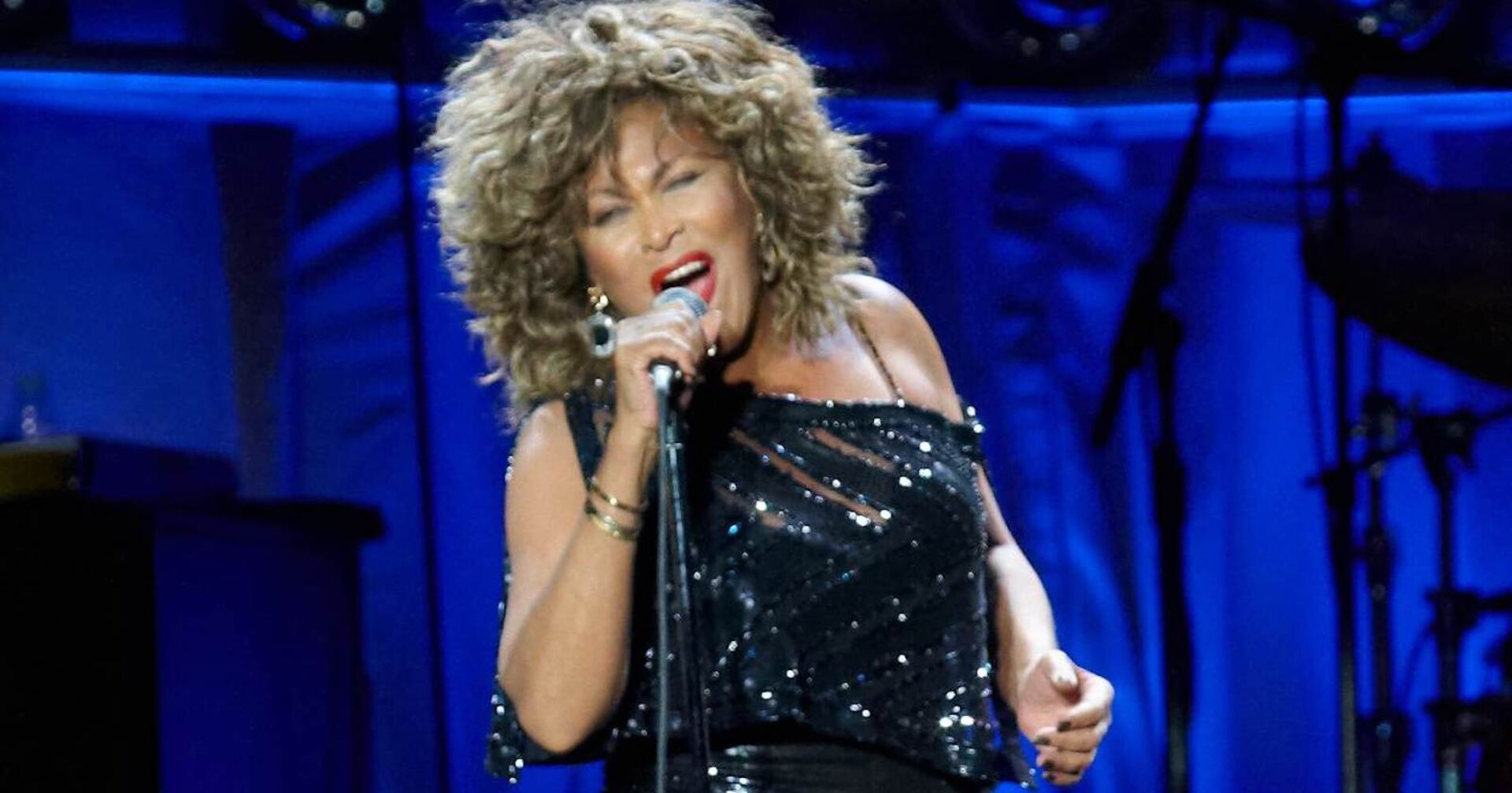 Tina Turner mit einem Mikrophon auf der Bühne