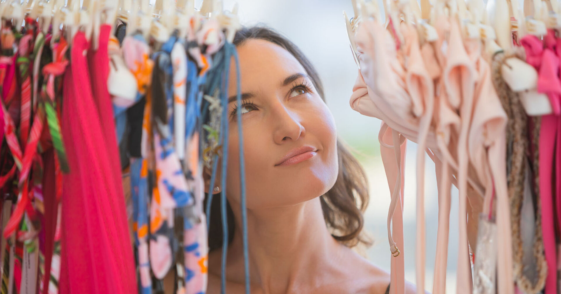 Frau schaut skeptisch auf Bikinis | Credit: iStock.com/Alina Rosanova