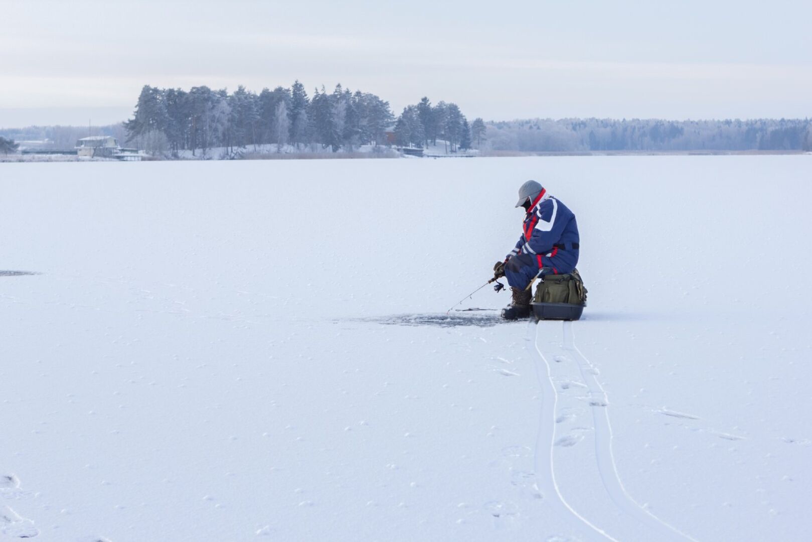 Mann beim Eisfischen in Schweden | Credit: iStock.com/smiltena