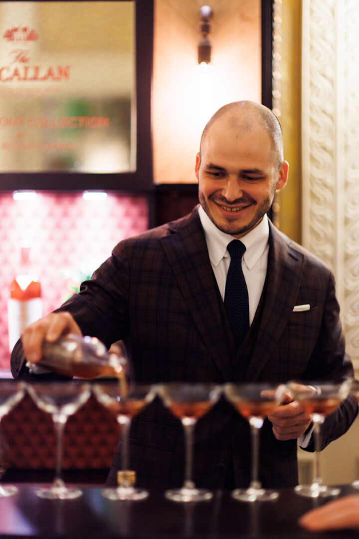 Barchef Nikolas Kröger im Anzug schenkt Cocktails ein | Credit: Adrian Almasan
